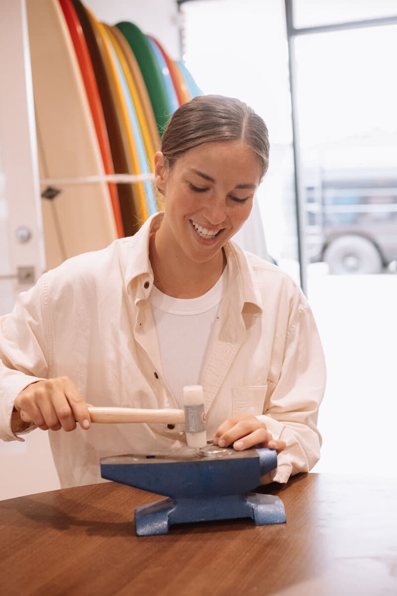 Sara Lundquist at her jewelry bench in San Clemente, hammering a ring on a mandrel