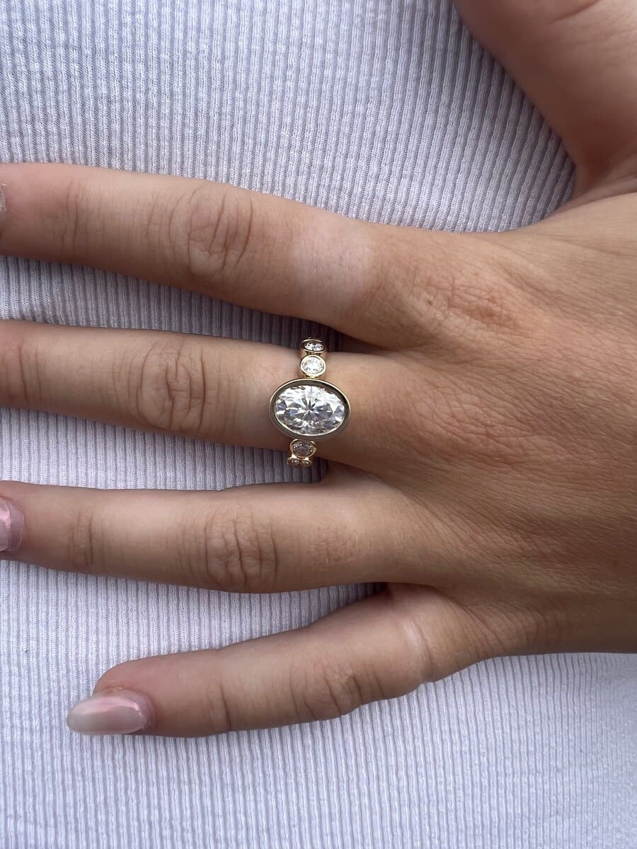 An oval diamond ring in white gold on a client's hand