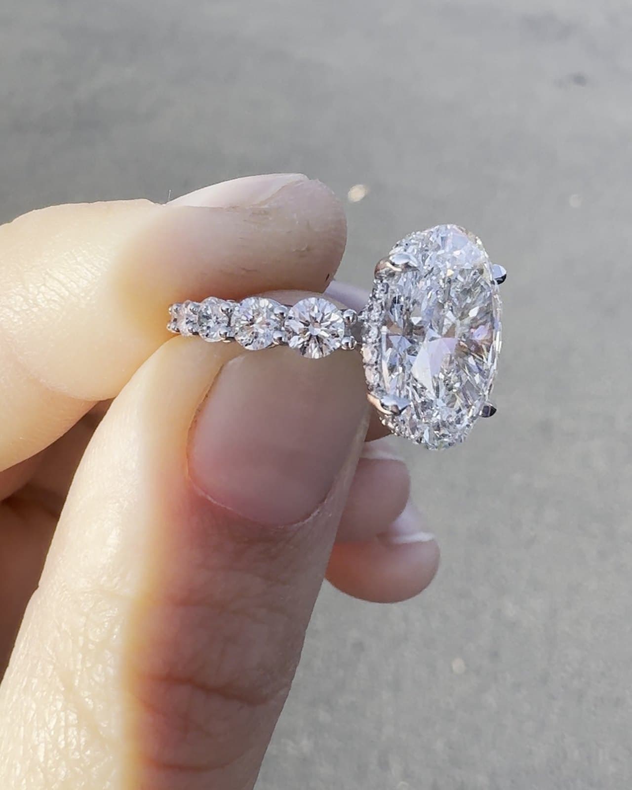 The same oval diamond ring turned to show its band of graduated round diamonds