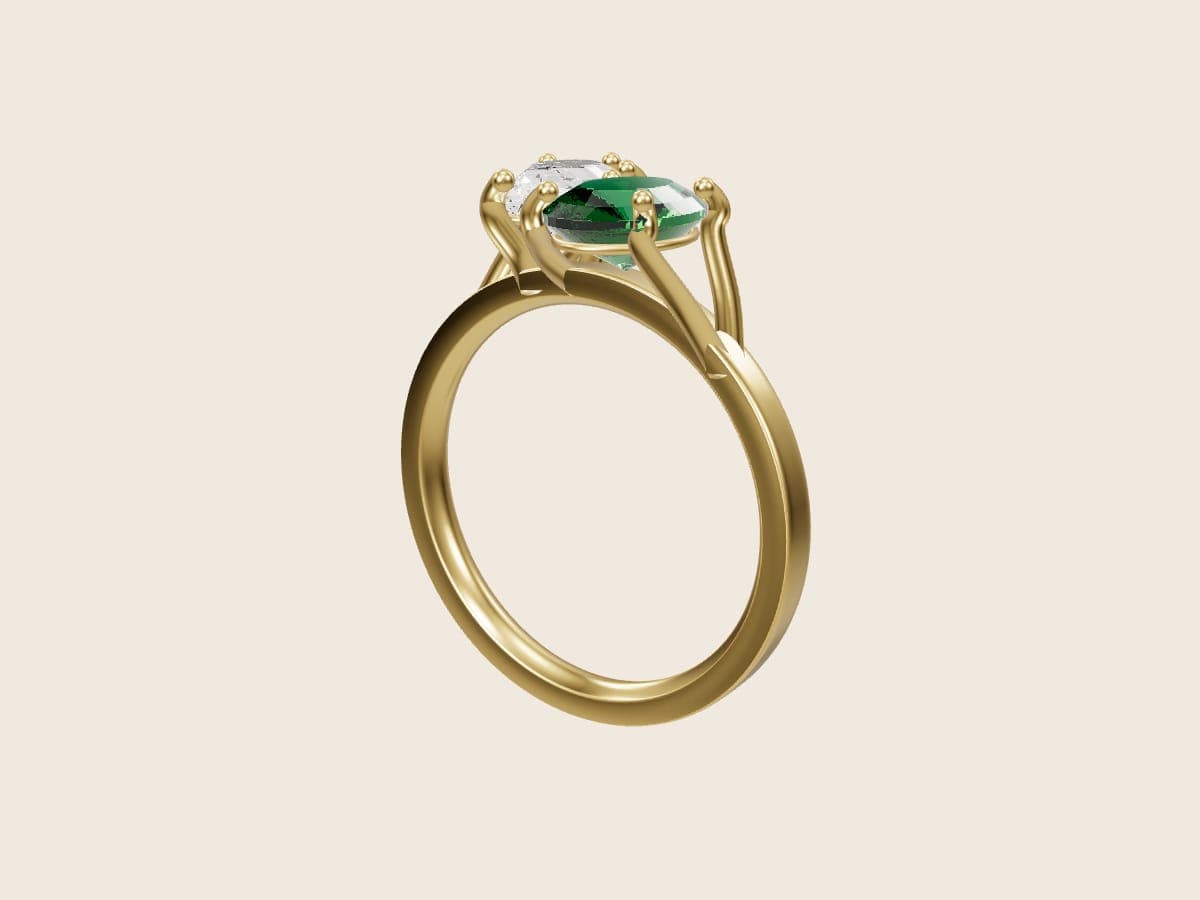 3D render of a toi et moi ring, a pear diamond and an oval emerald set on a diagonal in 14k yellow gold, from the Pacific Jewel Design Studio